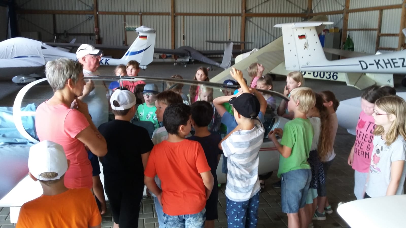 Kinder im Hangar mit Segelflugzeugen
