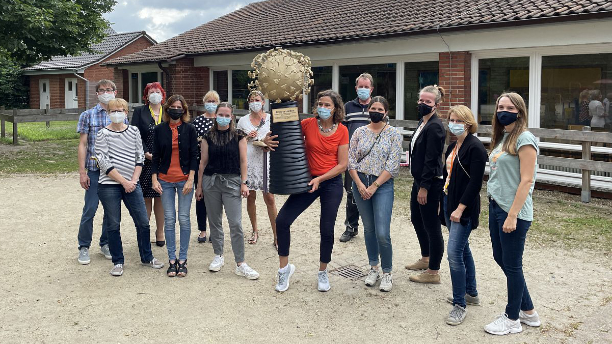 Gruppenfoto Lehrer mit dem Geschenk "Corona-Helden"