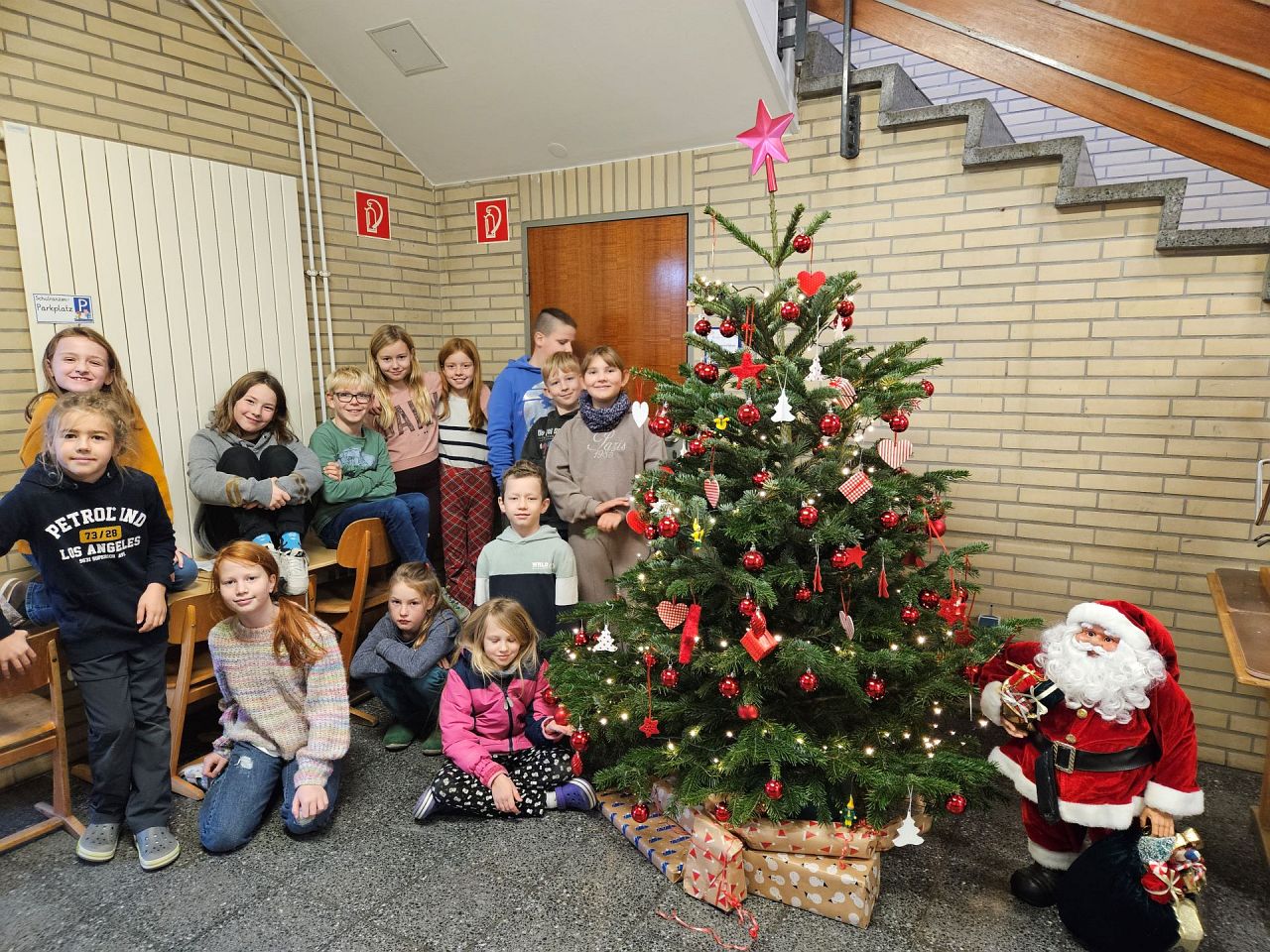 Gruppenfoto vor dem geschmückten Weihnachtsbaum der Schule